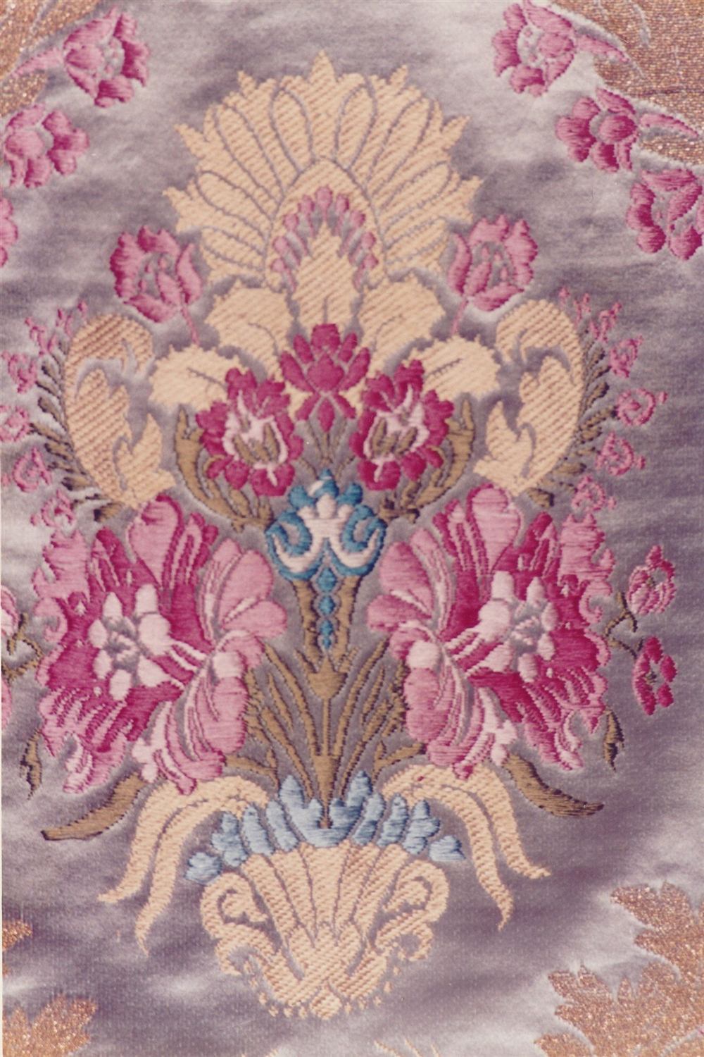 Detalle de bordado en seda con flores rosas, doradas y azules (imagen de archivo)